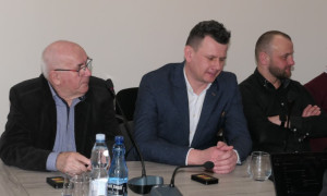 Trzej mężczyźni siedzą obok siebie. Trwają obrady rady gminy