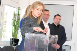 Kobieta stoi przy urnie do głosowania