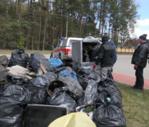 Na pierwszym planie czarne worki z odpadami zebranymi przez wolontariuszy podczas sprzątania rzeki Warty. 