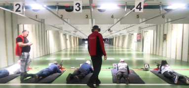 Pięć osób strzela z broni na strzelnicy sportowej 