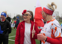Dwie kobiety w biało- czerwonych strojach. Kobiety trzymają biało-czerwoną flagę 