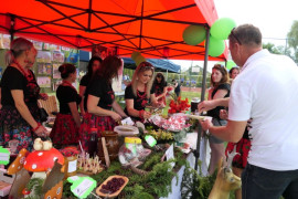 Stoisko z leśnymi potrawami: grupa osób podczas ich degustacji