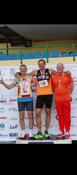 Trzej mężczyźni w strojach sportowych na podium