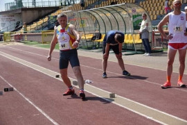 Trzech mężczyzn w strojach sportowych przygotowujących się do biegu