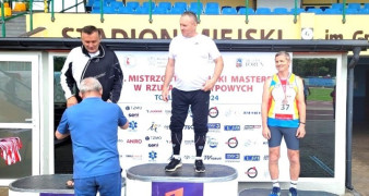 Trzej mężczyźni na podium. Pierwszy z lewej Piotr Płoskoński