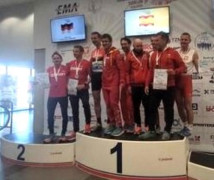 Zawodnicy w biało - czerwonych strojach stojący na podium 