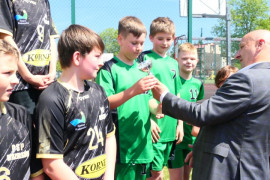 Mężczyzna podczas wręczania pucharu zawodnikom 