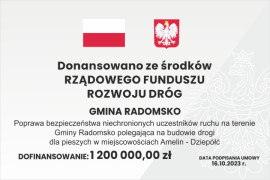 Tablica informacyjna z napisem: Dofinansowano ze środków Rządowego Funduszu Rozwoju Dróg. U góry tablicy znajduje się flaga i godło Polski