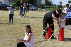 Dwie dziewczynki i strażak podczas wspólnej zabawy