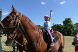 Dziewczynka na koniu z ręku uniesioną do góry