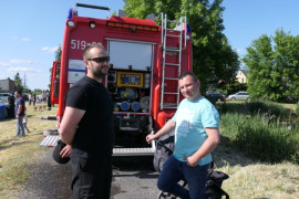 Dwaj mężczyźni przy wozie strażackim 