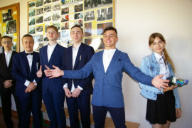 Grupa uczniów tuż przed egzaminem ósmoklasisty. Pięciu chłopców w garniturach i jedna dziewczynka w galowym stroju  