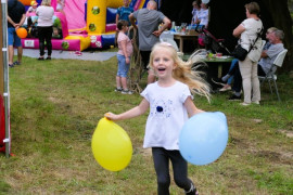 Dziewczyna trzymająca w ręku kolorowe balony
