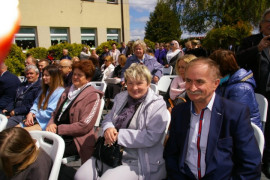 Mężczyźni i kobiety w cywilnych ubraniach siedzą na krzesłach