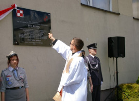 Ksiądz dokonuje poświęcenia tablicy