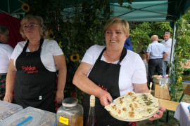 Dwie panie w reprezentacyjnych strojach - przedstawicielki Stowarzyszenia "Kobiety Kietlina" podczas prezentacji wyróżnionej potrawy - pierogów