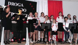 Grupa osób na scenie - osoby biorące udział w Wieczorze Patriotycznym 