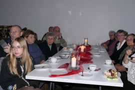 Grupa osób siedzących za stołem - uczestnicy Wieczoru Patriotycznego 