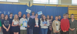Grupa młodych osób, uczniów tuż po zakończeniu matematycznego konkursu "Łyk matematyki" podczas wspólnego zdjęcia 