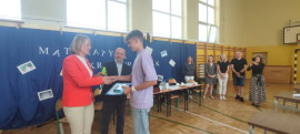 Uczeń odbiera gratulacje od dyrektor PSP w Płoszowie. Uczniowi gratuluje również wójt Gminy Radomsko