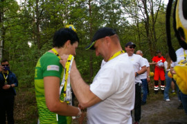 Kobieta i mężczyzna w strojach sportowych. Mężczyzna wręcza kobiecie medal w kształcie pszczoły