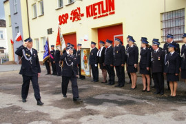 Grupa osób w mundurach strażackich. Dwóch mężczyzn dokonuje przeglądu OSP