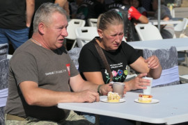 Kobieta i mężczyzna siedzą przy stole i jedzą ciasto