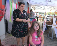Kobieta robi dziewczynce warkoczyka