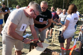 Mężczyzna podczas wbijania gwoździ w deskę 