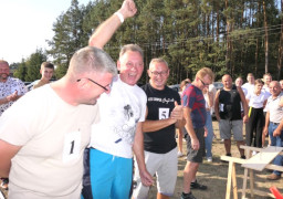 Trzech zadowolonych mężczyzn. Jeden z geście triumfu trzyma rękę w górze 