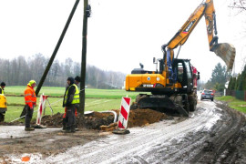 Robotnicy i maszyny budowlane przy pracach dot. budowy kanalizacji sanitarnej 