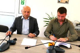 Dwóch panów podczas podpisywania dokumentów