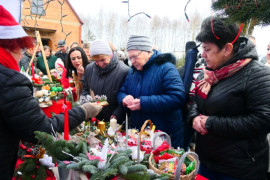 Grupa osób przy świątecznym stoisku 