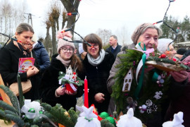 Grupa osób przy stoisku świątecznym 