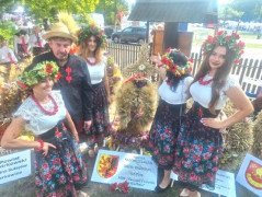 Grupa osób i wieniec dożynkowy 