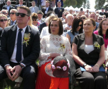 Osoby siedzą na krzesłach. Uczestnicy dożynek województwa łódzkiego