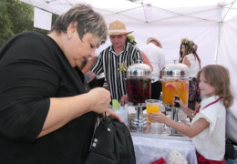 Osoby: dorośli i dzieci przy stoisku wystawienniczym 