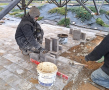 Osoby przy układaniu kostki brukowej 