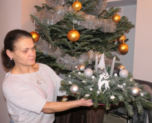 Kobieta prezentuje własnoręcznie zrobiony stroik świąteczny 