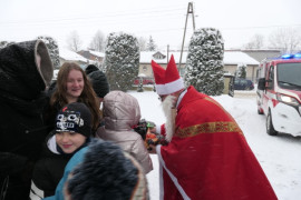 Mikołaj podczas wręczania dzieciom prezentów