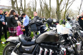 Motocykle i grupa osób na placu kościoła 