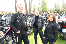 Kobieta i dwaj mężczyźni na tle motocykli 