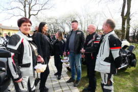 Grupa osób. W tle widoczne motocykle 