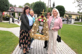 Kobiety niosą wieniec dożynkowy 