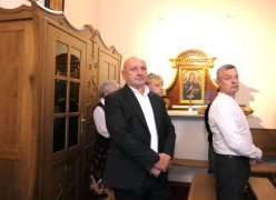 Mężczyźni stoją w ławach kościelnych 