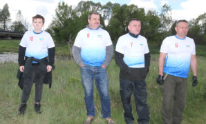Trzej mężczyźni i chłopiec stoją obok siebie. Za nimi płynie rzeka