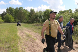 Trzej mężczyźni idą obok siebie polną drogą
