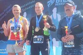 Trzech zawodników na podium. Pierwszy z lewej Piotr Płoskoński 