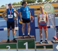 Trzej mężczyźni w sportowych strojach stoją na podium 