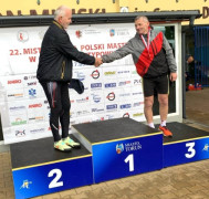 Dwaj mężczyźni na podium. Podają sobie dłonie